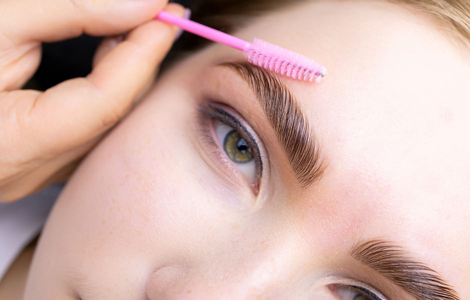 macro photography of the model's hairs the master combs the eyebrow hairs with a pink brus