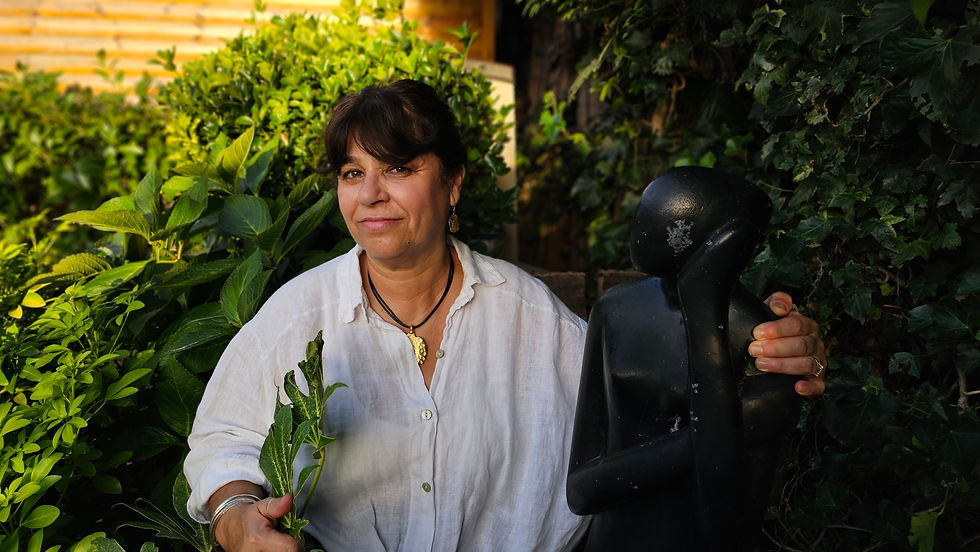 Neena with her arm around staue in her garden