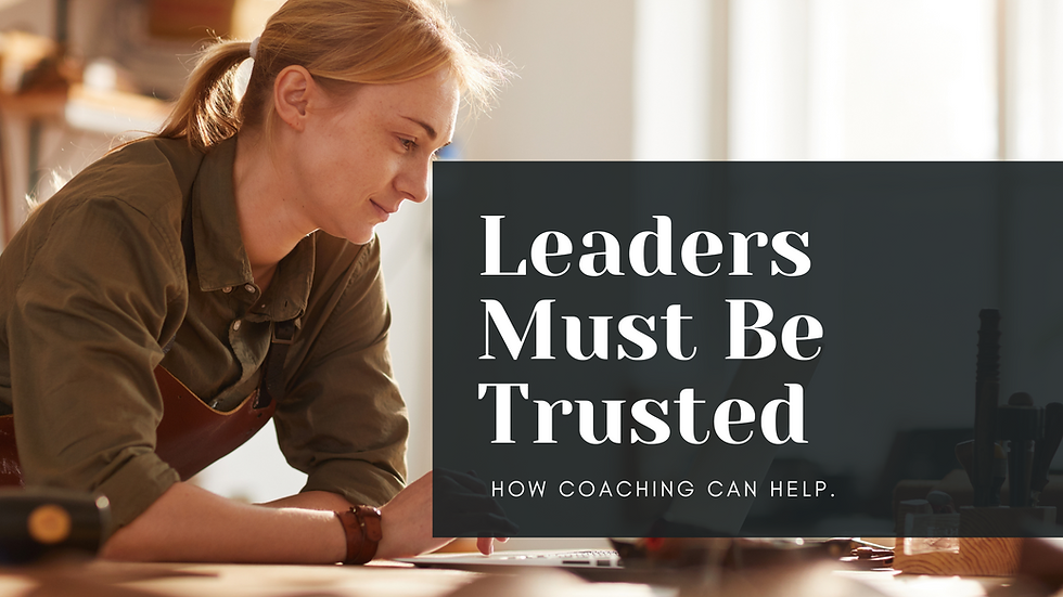 A person working at a desk wears an apron, smiling slightly. Text reads, "Leaders Must Be Trusted. How Coaching Can Help." Bright background.