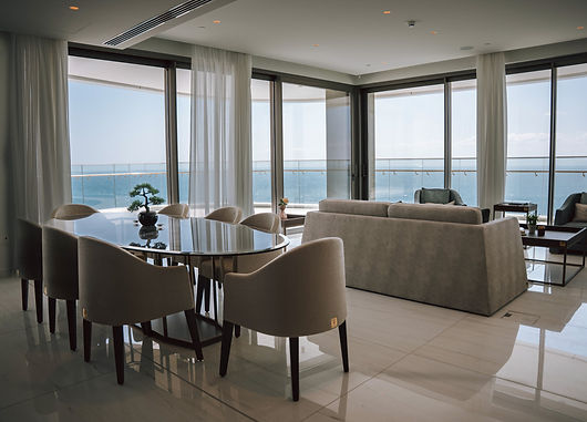 Open-plan luxury living room with floor-to-ceiling windows in Del Mar apartment for Century 21 listing