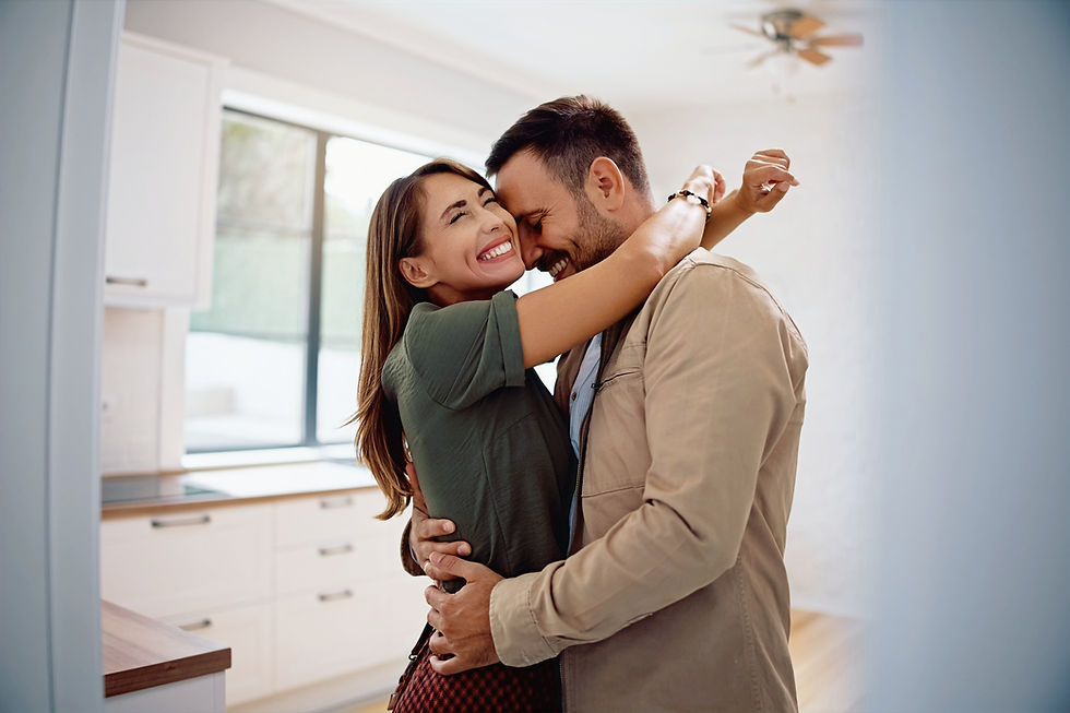 Ein Pärchen umarmt sich, weil es sich über den Hauskauf freut