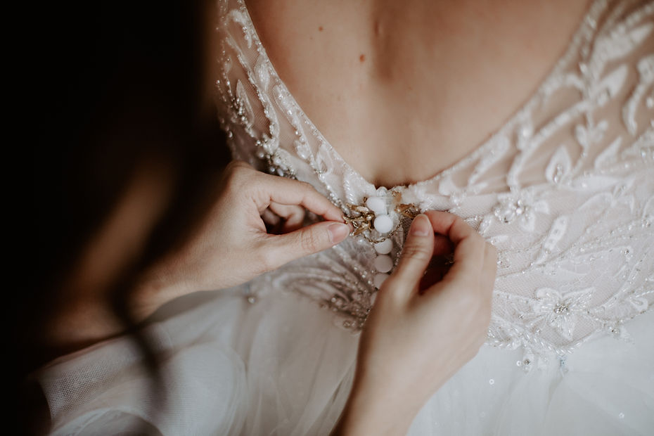 Close-up of a bride's beaded lace gown at the neckline