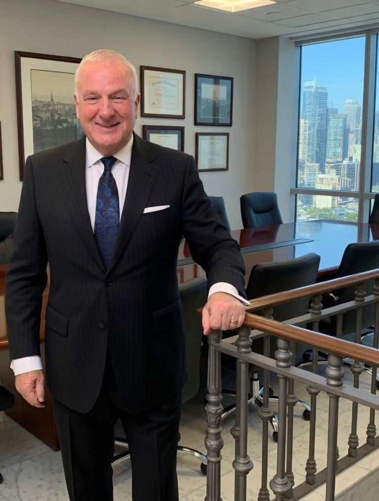 Portrait of a senior male lawyer in a dark suit standing in a modern boardroom with city skyline in the background, vertical portrait, professional corporate look.
