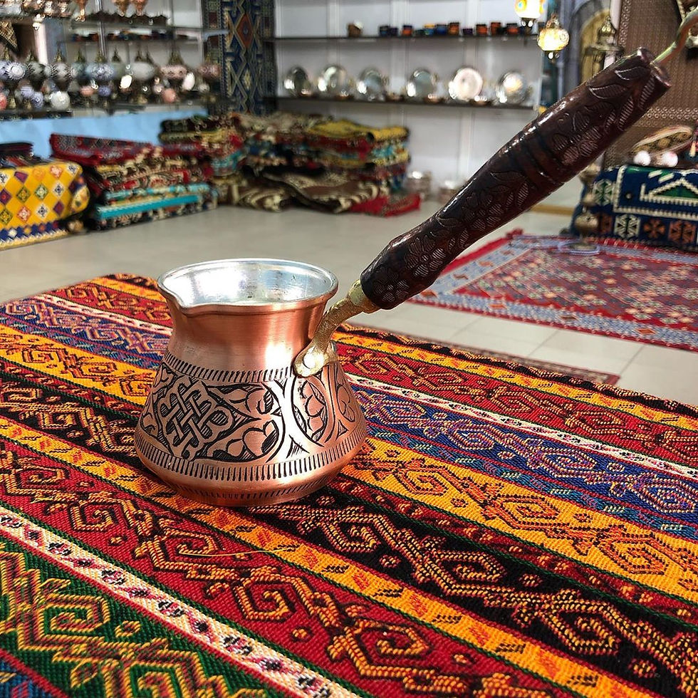 Eye-level view of a traditional copper cezve with a wooden handle
