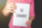 A lady in a pink shirt holding up a pad with the words "no comment" written on it
