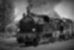 A steam train pulling out of a station