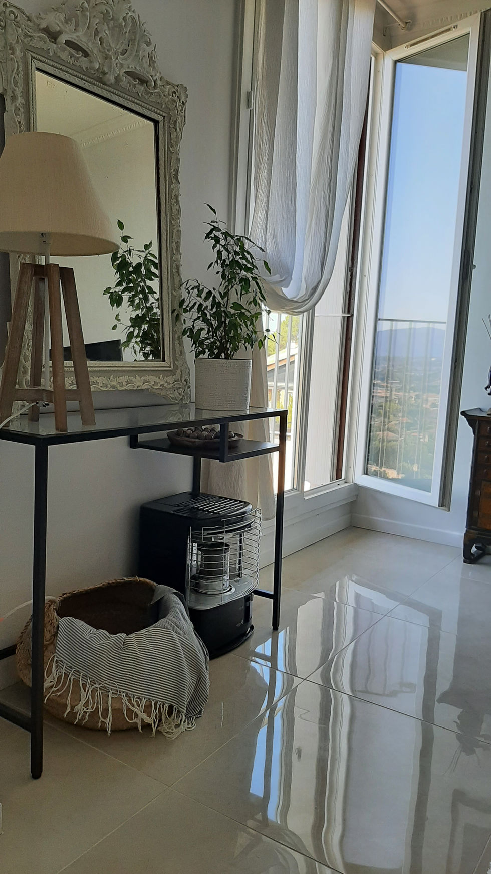 Console moderne en métal sous miroir ancien mouluré, déco mixte chic et vintage.