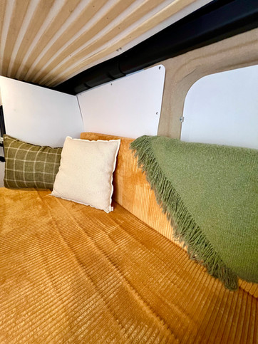 Banquette transformable en lit dans un van aménagé 2 personnes disponible à la location