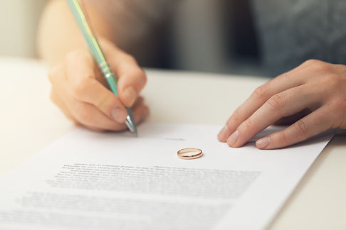 Woman signing divorce papers drawn up by Epstein Law Firm