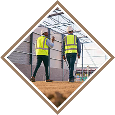 diamond shaped, color photo of two construction workers discussing a build