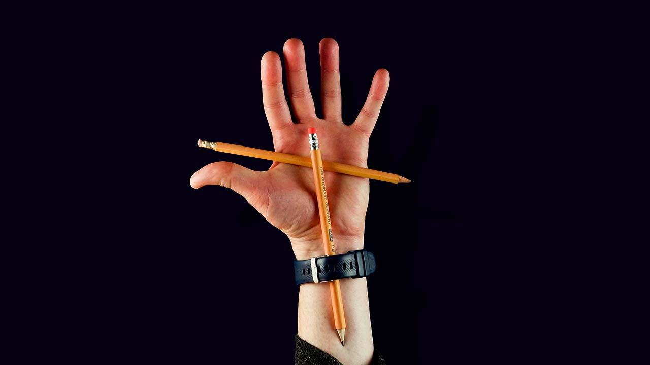 Exposed view of the magic trick shows a pencil secretly holding the pencil behind the magicians hand