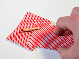 magician slides a card underneath the match floating above the card