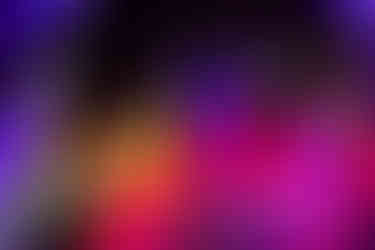 Corporate magician Ryan Joyce standing on stage with colourful lights behind him