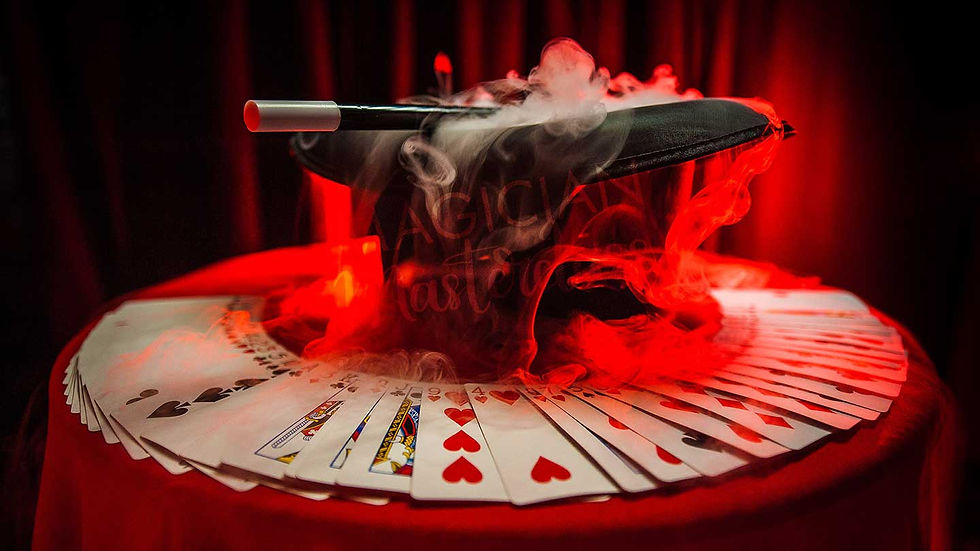 Magician Top Hat, Magic Wand and Playing Cards spread on a magician table