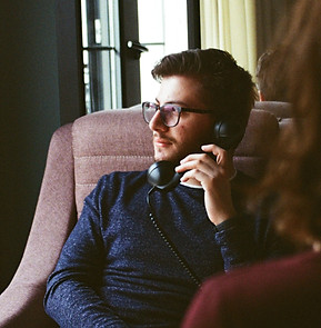 man in blue sweater sitting on brown sof
