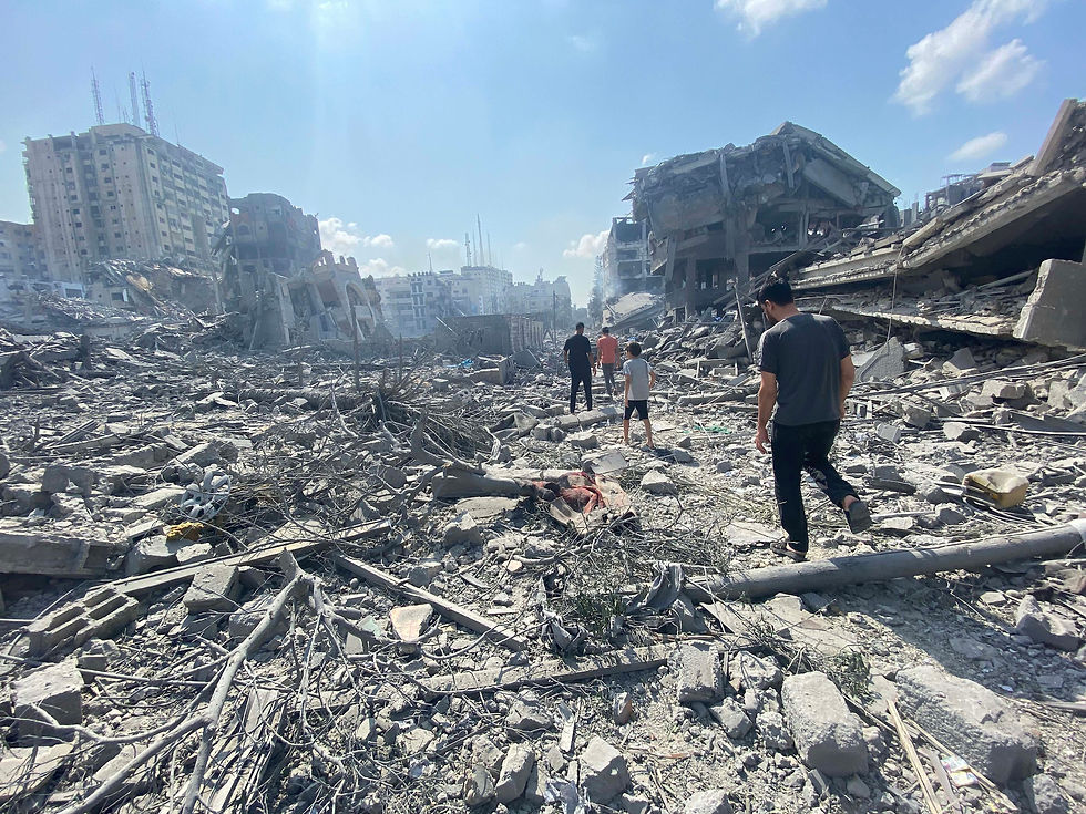 People walking across rubble in Gaza in October 2023