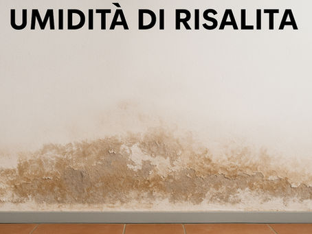 Parete interna con evidenti segni di umidità di risalita nella parte bassa: intonaco danneggiato, macchie scure e pittura scrostata sopra un pavimento in piastrelle di cotto.