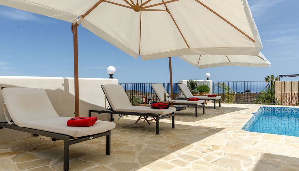 Terraza con tumbonas y piscina con vistas al mar