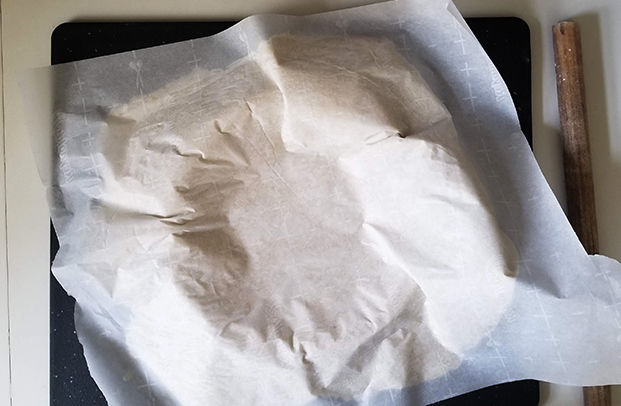 pie dough with parchment paper on top