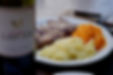 Bottle of wine with a plate in the immediate background with steak and mashed potatoes