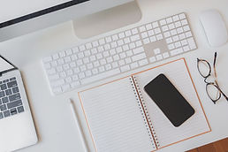 desk with a notebook, phone and keyboard