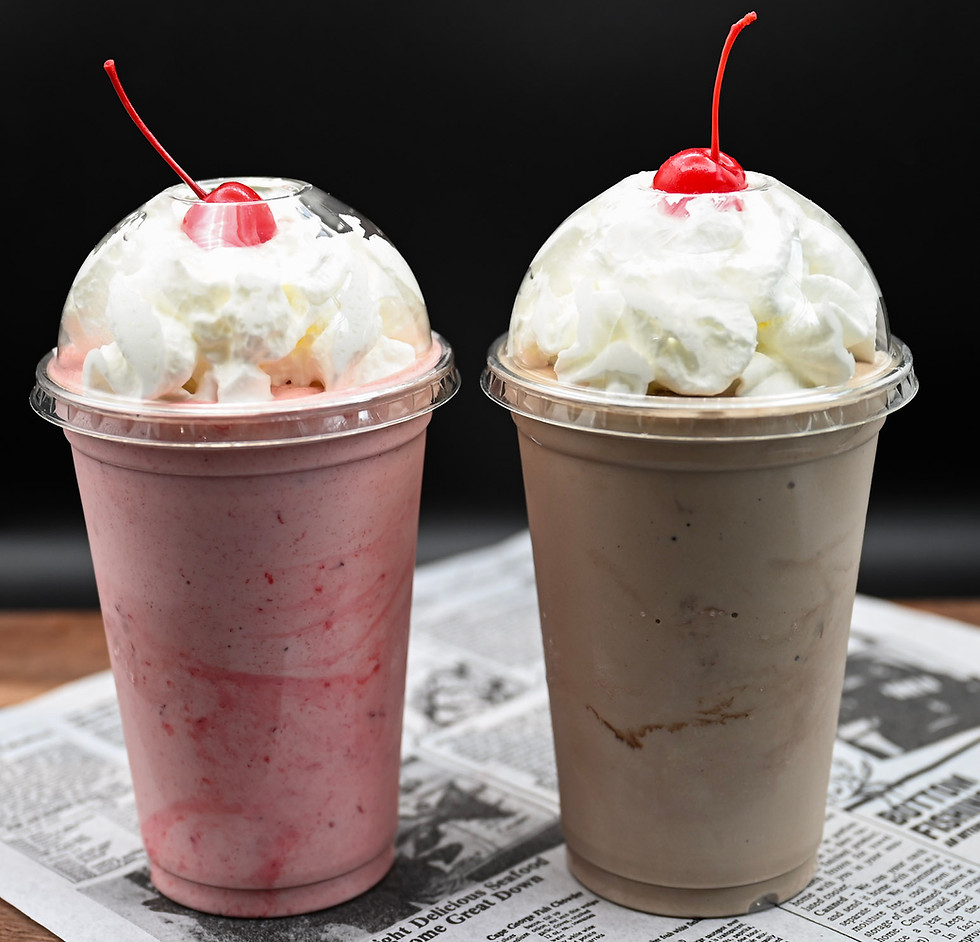 Strawberry and chocolate milkshakes topped with whipped cream and a cherry on top at Penelope's World Famous Burgers & Fries in Estes Park