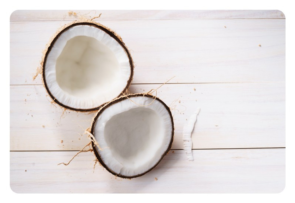 coconut with shell on white wooden background