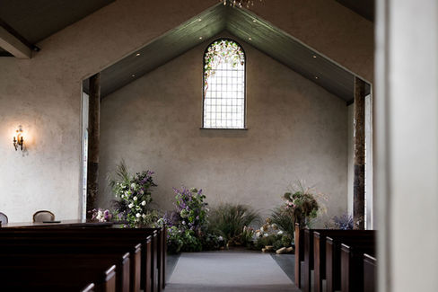 Lush green and mauve ceremony floral installation