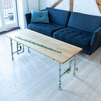 Incy Wincy Spider oak coffee table with an inserted clear bar of leaves cast in epoxy. Legs of steel pipes