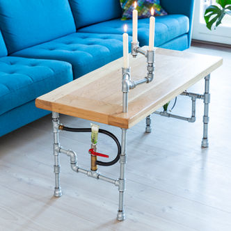 Chlorophyll coffee table of thick natural oak, a candlestick of steel pipes extends across the table and steel pipe legs