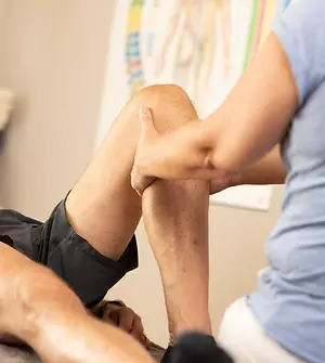 Yvonne Scholz behandelt Patient am Bein