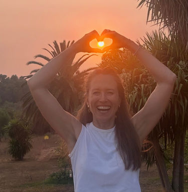 Lachende Frau mit Herzmotiv und Sonne