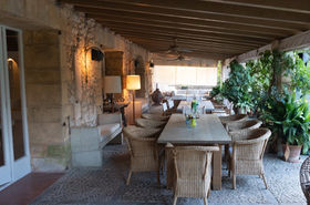 Covered terrace with a long dining table at the Son Sard finca in Mallorca