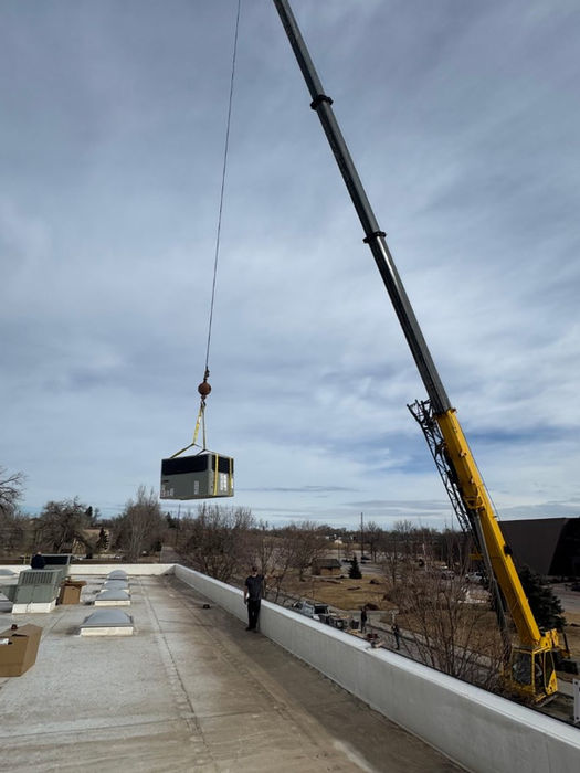 Complex HVAC ductwork being placed on a rooftop with a crane in Rapid City.