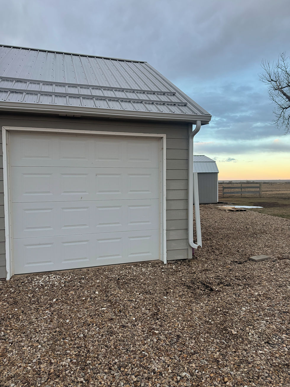 Gray garage with white door and white gutters