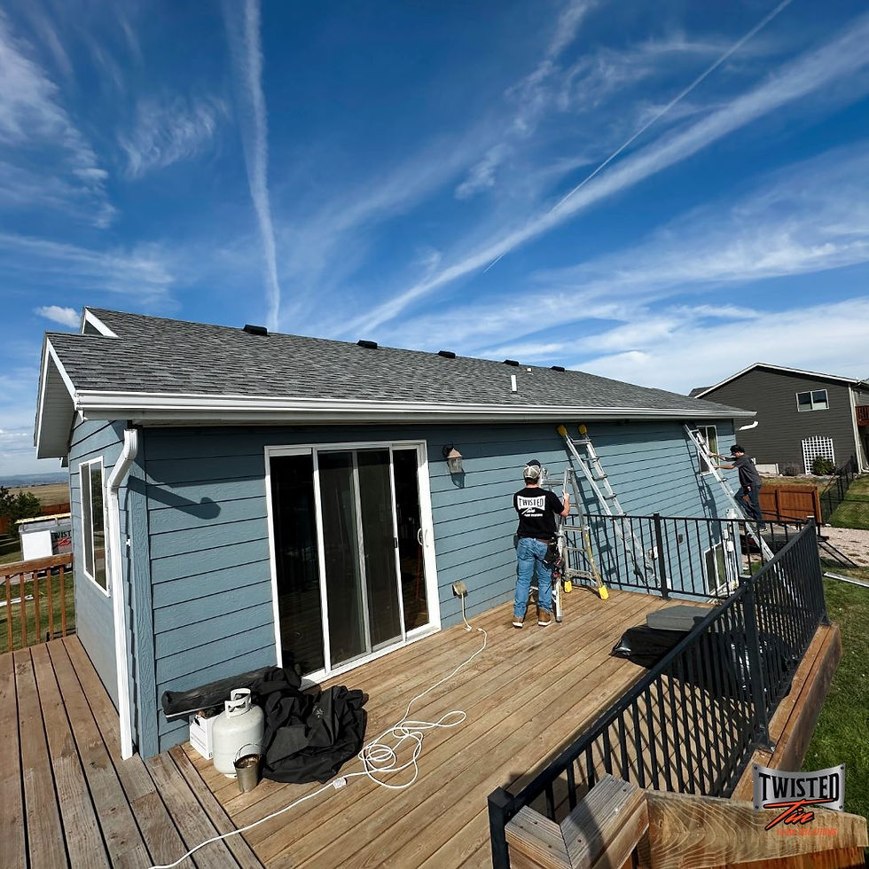 Blue house with Twisted Tin employee working on the white gutters