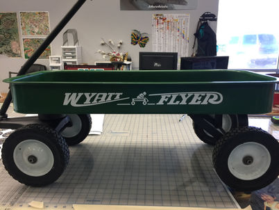 Green wagon with "WYATT FLYER" text and logo, sitting on table.