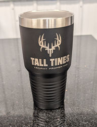 Black Tall Tines trophy properties tumbler with logo on a counter surface.