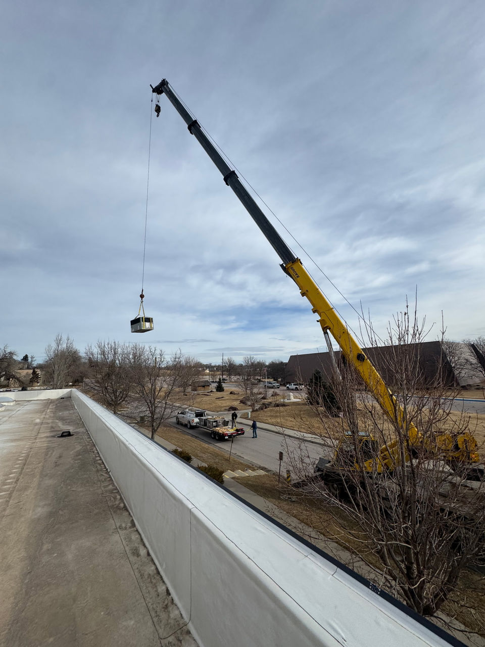 Crane moving HVAC onto a roof