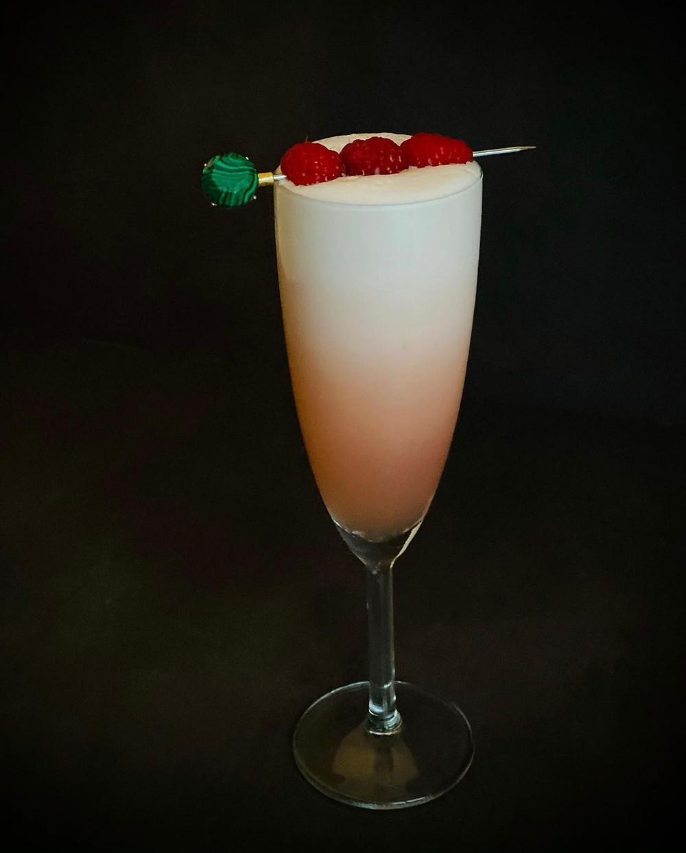Clover club cocktail met mezcal, vlierbloesemlikeur, framboos en eiwit
