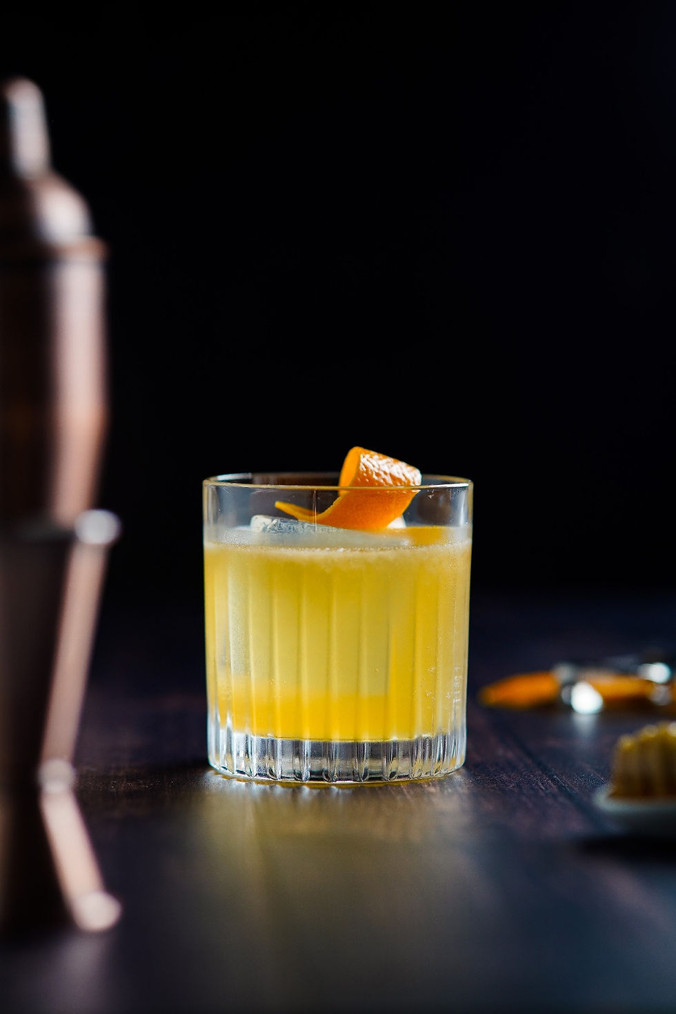 Penicillin cocktail met rokerige whisky, honing-gember siroop en een sinaasappelschil garnering