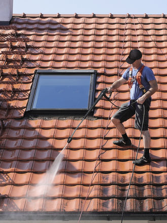 Softwash roof cleaning in Orlando FL using low-pressure method to remove algae, moss, and black streaks