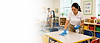 CleanPro 360 employee cleaning a childcare classroom with a microfiber cloth while another employee vacuums in the background