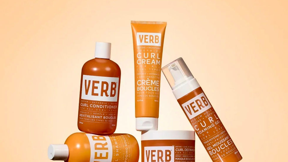 Eye-level view of hair stylist applying VERB curl cream on damp hair