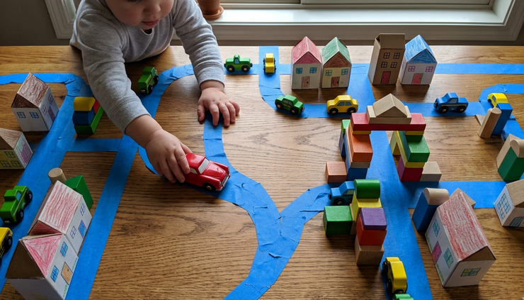 Overhead view of painter’s tape roads winding across a playroom floor.