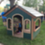 Kid's green, tan, and terra cotta playhouse with doors, windows, flooring, and roof at daycare school playground