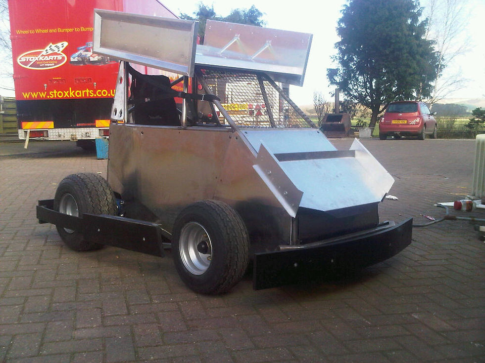 Close-up view of a short oval race car on the track with safety barriers