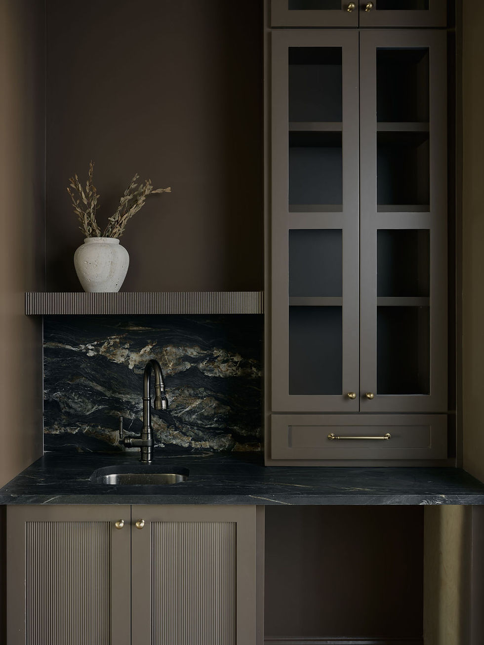 Residential interior design - dark, moody wet bar with marble backsplash.