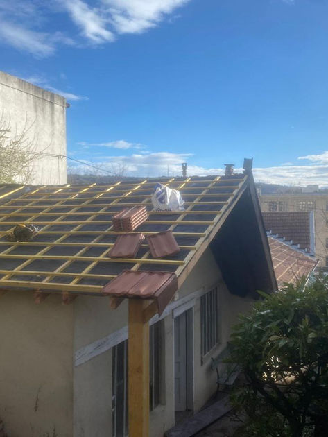 installation des tuiles sur la toiture apres son remplacement complet par charpentier 42