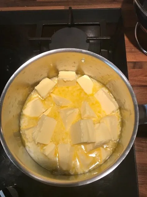 Beurre doux non fondu dans une casserole à fond épais, prêt à être clarifié pour faire du ghee.